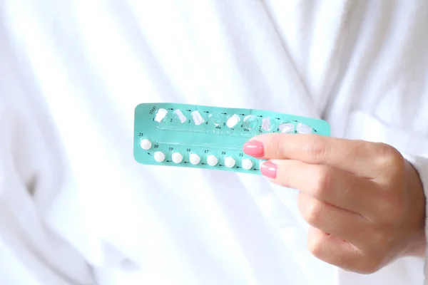 Woman hand holding contraceptive pills,  birth control medicine