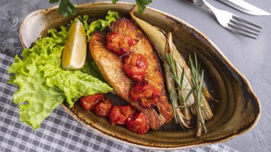 Domatesli fırında somon filetosu ve tabakta sert kereviz. Diyet ve sağlıklı gıda konsepti. Üst görünüm