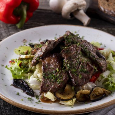 Kızarmış dana eti ve sebzeli sıcak salata. Yakın çekim.