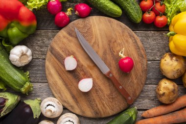 Kesme tahtası ve bıçaklı taze sebzeler. Üst görünüm