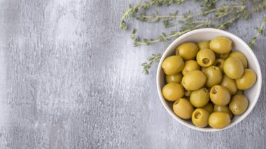 Gri arkaplanda yeşil zeytin ve fotokopi alanı. Üst görünüm