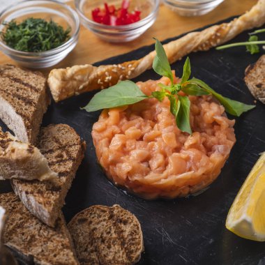 Çıtır ekmek ve taze limonlu lezzetli somon tartar. Çiğ somon tartar.