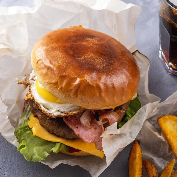 Domuz pastırmalı, yumurtalı ve peynirli ev yapımı sığır etli burger. Yakın çekim.