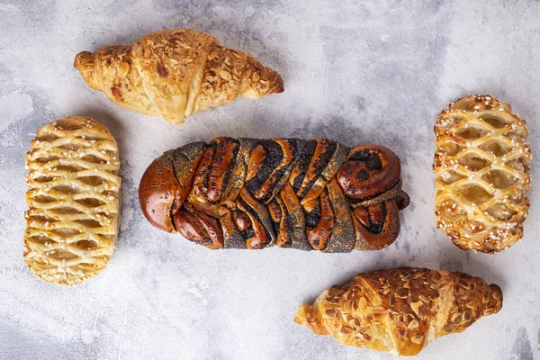 Pâtisseries fraîches fond. Croissants et pain d'osier aux graines de pavot. Vue du dessus — Photo