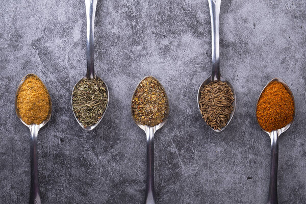 Специи в ложке. Стол с различными специями. Различные ложки специй
