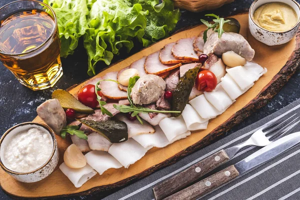 Assorted of sliced smoked meat products  and lard on wooden board.