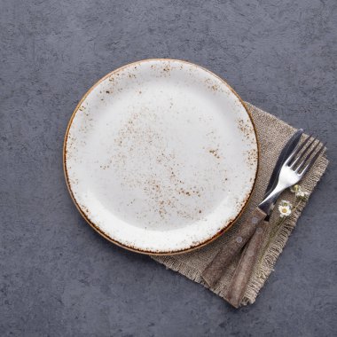 Boş tabak ve çatal bıçak takımı peçeteye. Üst görünüm