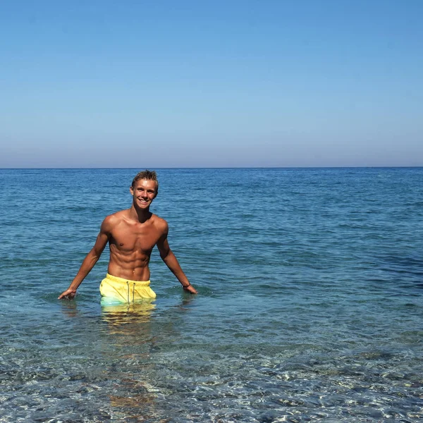 Nice guy smiling in the sea. Holiday in a sea. Summer time
