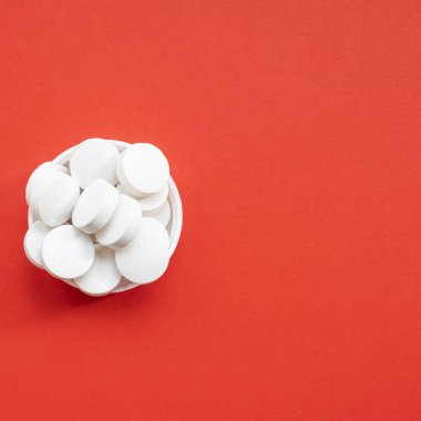 Kapaktaki beyaz tabletlerin üst görüntüsü. Boşluğu kopyala