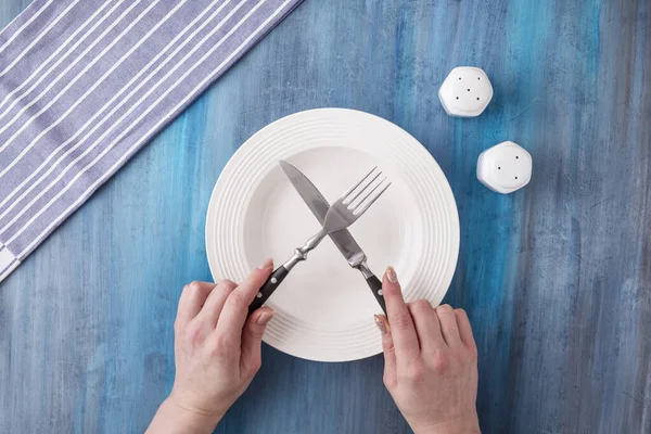 Female hands holding fork and knife over