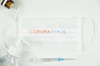Tıbbi maske, şırınga, hap ve el dezenfektanı jeli. Coronavirus konsepti. Üst görünüm
