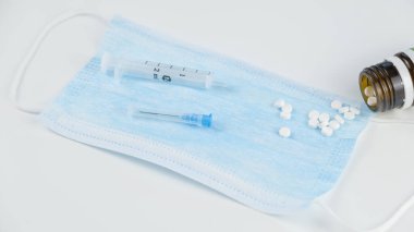 Coronavirus önleme tıbbi çağrı mavi maske, şırınga ve haplar beyaz arka planda. 