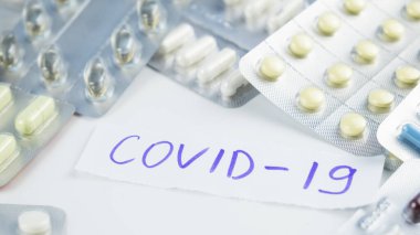 Metin cümlesi COVID-19 ve beyaz arka planda haplar. Virüs kavramını durdur. 