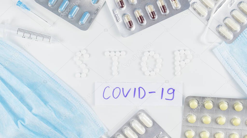 Novel coronavirus disease named COVID-19 written on paper with medicines. Stop coronavirus concept. Top view