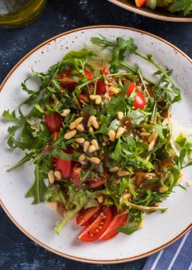 Çam fıstıklı, domatesli ve peynirli rugula. Sağlıklı taze salata ve roka. Üst Manzara. Yakın çekim.