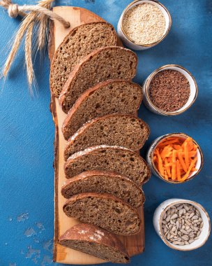 Havuçlu ekmek. Keten tohumlu havuç ekmeği, susam tohumu ve ayçekirdeği dilimliyor. Sağlıklı yiyecekler. Beslenme ve vejetaryen yemekleri. Üst Manzara. Yakın çekim.