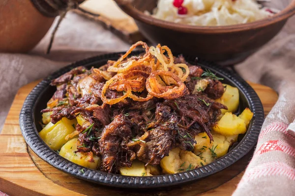 Kızartma tavasında patates ve soğanlı biftek kuyruğu..