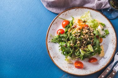 Arugula salatası, çam fıstığı, domates ve peynir. Üst Manzara. Boşluğu kopyala