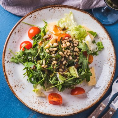 Arugula salatası, çam fıstığı, domates ve peynir. Üst Manzara. Yakın çekim.