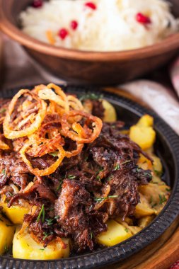 Kızartma tavasında patates ve soğanlı lezzetli biftek kuyrukları. Yakın çekim.