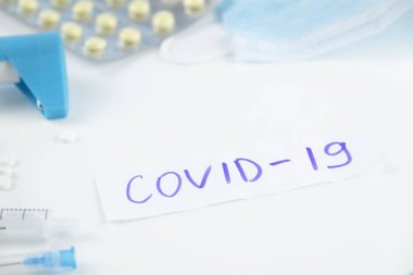 COVID kelimesi. Peper 'a 19, beyaz arka plana da ilaçlar yazılıyor..