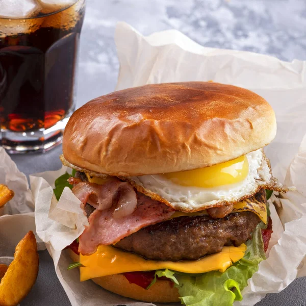 Kızarmış pastırmalı ve yumurtalı ızgara biftek, peynir, domates ve marul. Fast food. Yakın çekim.