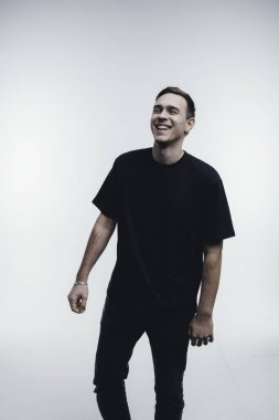 Siyah elbiseli, beyaz arka planda gülen gençler.