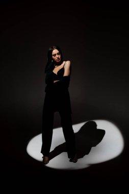 Sütyenli güzel esmer kadının stüdyo fotoğrafı mesafeye bakıyor.