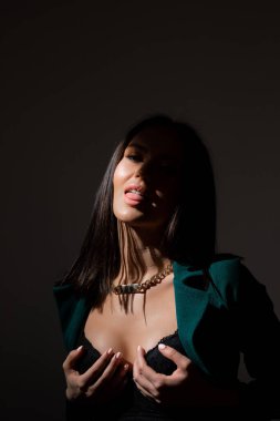 Sütyenli güzel esmer kadının stüdyo fotoğrafı mesafeye bakıyor.