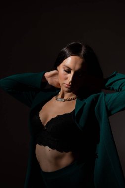 Sütyenli güzel esmer kadının stüdyo fotoğrafı mesafeye bakıyor.