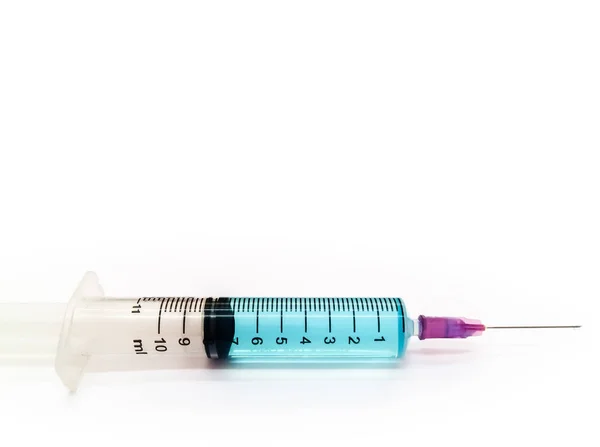 Fecho da seringa sobre fundo branco, Seringa com soro azul — Fotografia de Stock