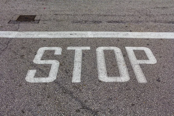 Word Stop escrito en un camino de asfalto, Stop Sign — Foto de Stock