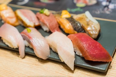 Sigorta primi Sushi Set Hamachi, Hotate, Toro siyah taş plaka üzerinde