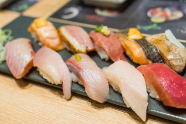 Sigorta primi Sushi Set Hamachi, Hotate, Toro siyah taş plaka üzerinde