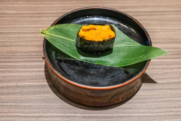 Uni Sushi comida japonesa en plato negro sobre mesa de madera —  Fotos de Stock