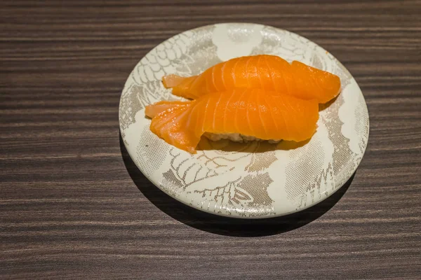 Sushi di salmone giapponese fresco in piatto bianco sul tavolo di legno — Foto Stock