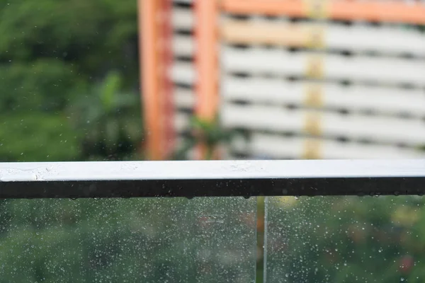Rain drops on glass balcony, rainy day and apartment