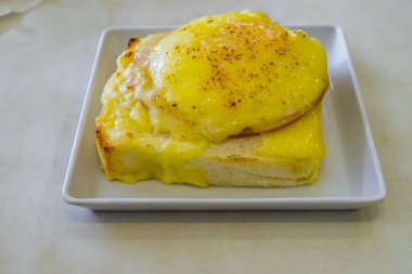Jambon ve peynir beyaz masada yumurtalı ekmek dolması