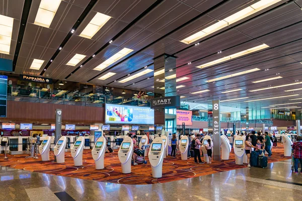 Посетители прогуливаются по Залу Вылетов в аэропорту Чанги Сингапур Стоковое Изображение