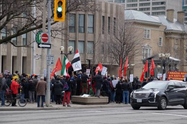 TORONTO, CANADA - 01 04 2020: Protesters against US President Donald Trump's ordering of the death of the Iranian general Qassem Soleimani at an anti-war rally outside the U.S. Consulate in Toronto clipart