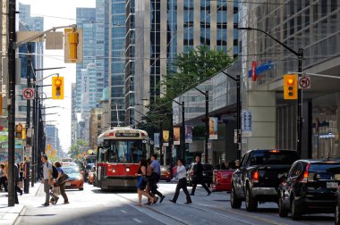 Toronto, Kanada - 06 28 2016: Yaz öğleden sonra Toronto şehir merkezinde eski bir tramvayın önünde King Caddesi 'nden geçen yayalar.