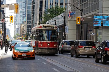 Toronto, Kanada - 06 28 2016: Eski TTC tramvayı yazın öğleden sonra Toronto şehir merkezinde King Caddesi boyunca trafikte ilerliyor.
