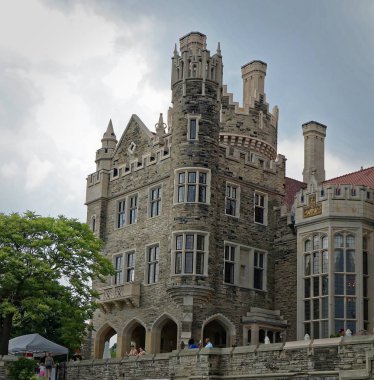 TORONTO, CANADA - 06 20 2016: Casa Loma building before a dark cloudy sky. Casa Loma is a Gothic Revival castle-like building that has become one of the most famous landmarks of Toronto, major