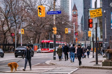 TORONTO, CANADA - 01 04 2020: Queens Caddesi 'ndeki Üniversite Bulvarı' ndan Cadillac Fairview Kulesi 'nin önündeki eski belediye saat kulesiyle geçen yayalar Toronto şehir merkezinin arka planında