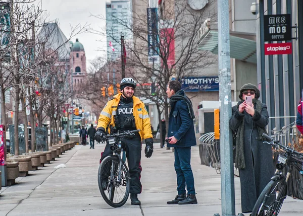 TORONTO, CANADA - 01 04 2020: Toronto Polis Devriyesi Toronto şehir merkezindeki Üniversite Bulvarı 'nda bir adamla konuşuyor