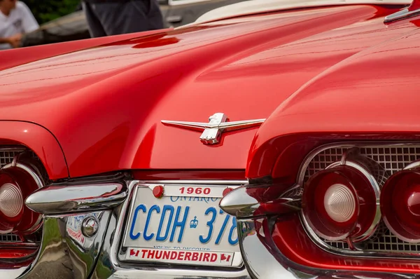 TORONTO, CANADA - 08 18 2018: Thunderbird logotyp med bakljus, krom stötfångare och sidodekorationer av röd 1960 Ford Thunderbird cabriolet oldtimer bildisplay på auto show Hjul på Danforth — Stockfoto