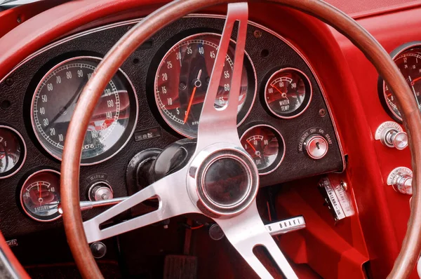 Partie de l'intérieur avec volant, indicateur de vitesse, régime, carburant, huile, température de l'eau et cadrans et boutons de batterie sur le panneau avant de la voiture de sport oldtimer rouge — Photo