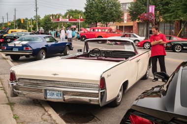 TORONTO, CANADA - 08 18 2018: Amerikan otomobil üreticisi Ford Motor Company 'nin bir bölümü olan Lincoln tarafından yapılan 1964 Lincoln Continental üstü açılabilir eski zaman aracı - Danforth' un yanındaki Wheels on the Danforth açık hava otomobil fuarının ziyaretçisi.