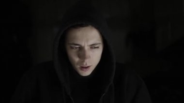 Bipolar bozukluğu olan bir adam dramatik ışıklarda güler ve sinirlenir. Deli ya da paniğe kapılmış görünüyor. Onun keskin bir ruh hali var.