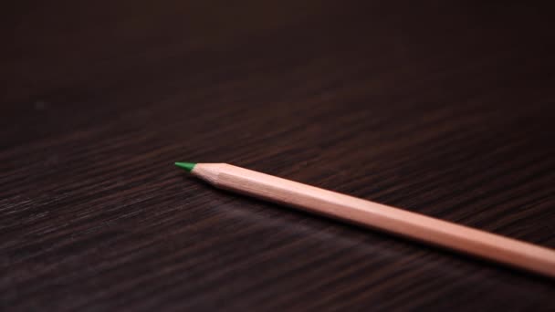 Pencils are laid on a wooden table in turn — Stock Video